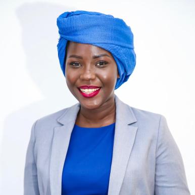 Gnagna Lam headshot African woman wearing a bright blue head scarf smiles into the camera