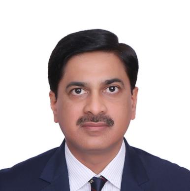 Laeeq Ahmed headshot Man wearing a blue suit, with a brown moustache, looks into the camera
