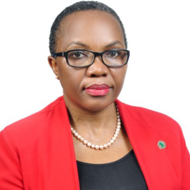 Martha Phiri headshot Woman with short hair wearing a red blazer, looks into the camera