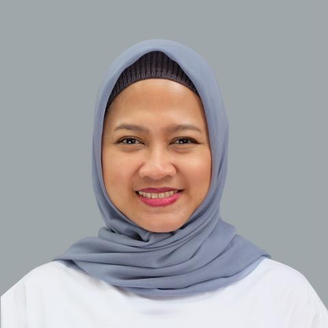 Indonesian woman wearing a gray-blue headscarf smiles into the camera