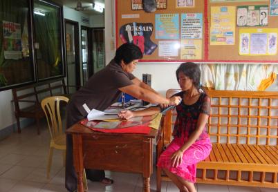 One woman puts a blood pressure cuff on another