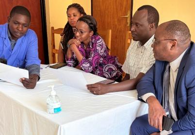 Rwanda impact story 5 people sit around a table