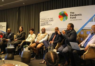 South Africa project launch People sit on a panel in front of the Pandemic Fund logo