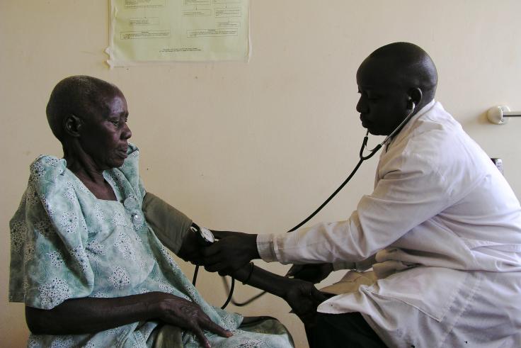 Doctor is examining a young man in Uganda